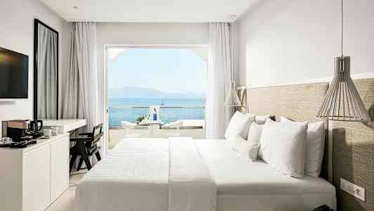 Hotelværelse med dobbeltseng og havudsigt. (AI-genereret tekst)