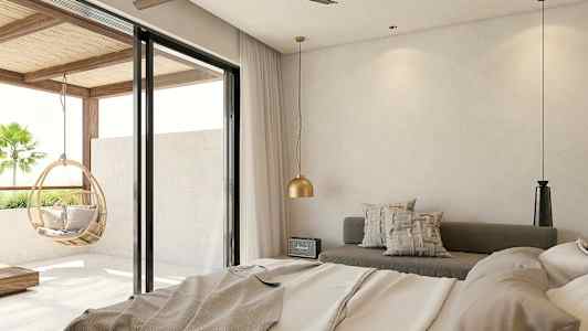 Et hotelværelse med moderne design, med en seng, siddeområde og store glasdøre, som giver udsigt til altanen med en hængende kurvestol. (AI-genereret tekst)