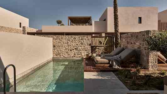 Moderne bygninger, pool og liggestole udendørs. (AI-genereret tekst)