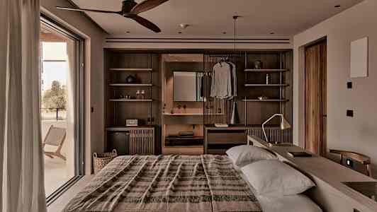 Et varmt indrettet soveværelse med dobbeltseng, trædetaljer og en bred altandør. (AI-genereret tekst)