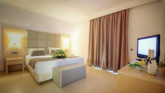 Hotelværelse med en dobbeltseng og en blomsterdekoration. (AI-genereret tekst)