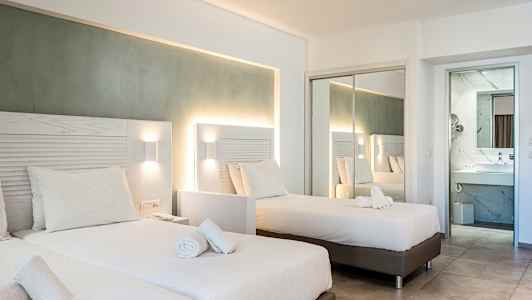 Et hotelværelse med to enkeltsenge og en spejlvæg, der reflekterer rummet. (AI-genereret tekst)