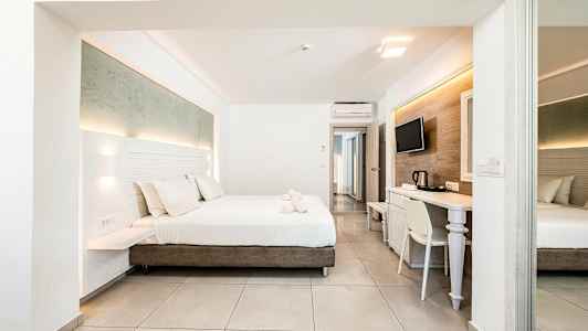 Et moderne hotelværelse med en dobbeltseng, skrivebord og TV. (AI-genereret tekst)