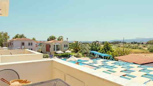 Udsigt fra en terrasse over huse, grønne områder og landskab. (AI-genereret tekst)