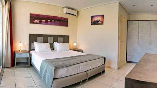 Et hotelværelse med en dobbeltseng, to natborde og dekorative vægbilleder. (AI-genereret tekst)