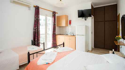 Hotelværelse med tre senge, garderobe, aircondition og tekøkken. (AI-genereret tekst)