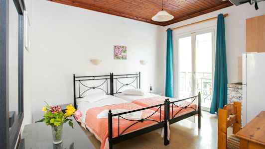 Et hotelværelse med to enkeltsenge og en vase med blomster på et bord. (AI-genereret tekst)