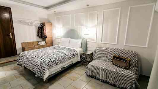 Et hotelværelse med en seng, en sofaagtig siddeplads og et garderobeskab. (AI-genereret tekst)