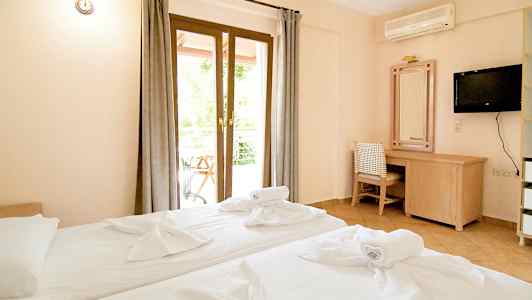 Hotelværelse med to senge, skrivebord og tv. (AI-genereret tekst)