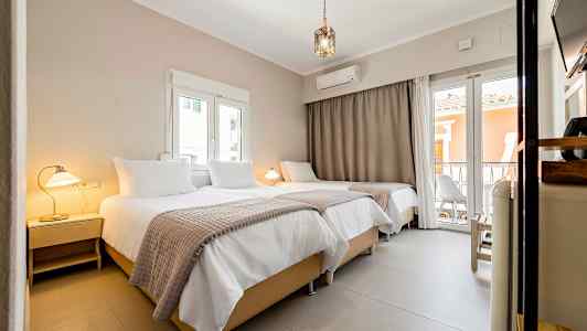 Interiør af et hotelværelse med tre senge, lamper og vinduer. (AI-genereret tekst)