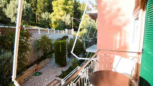 Altan med bord vendende ud mod en have med stenlagt sti og grønt. (AI-genereret tekst)