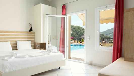 Hotelværelse med seng, åben glasdør og udsigt til poolområdet og omkringliggende natur. (AI-genereret tekst)