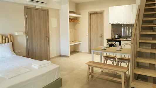 Et moderne værelse med seng, spisebord, køkken og trappe. (AI-genereret tekst)