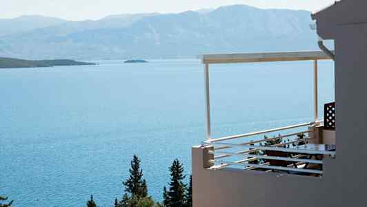 En altan med udsigt over havet og omkringliggende bjerge. (AI-genereret tekst)