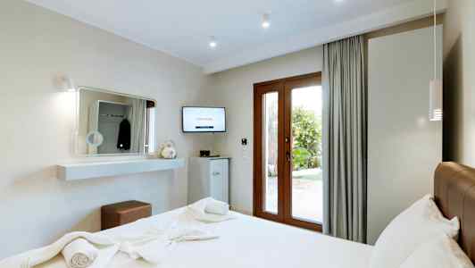 Moderne hotelværelse med en dobbeltseng og udsigt til haven. (AI-genereret tekst)