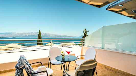 En terrasse med bord, stole og havudsigt. (AI-genereret tekst)