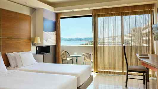 Værelse med to enkeltsenge, en altan med havudsigt og siddepladser. (AI-genereret tekst)