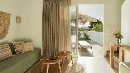 Moderne rum med grøn sofa, træmøbler og en glasdør der fører til en terrasse med pool. (AI-genereret tekst)