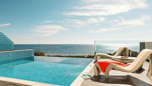 Liggestole ved en pool med havudsigt. (AI-genereret tekst)