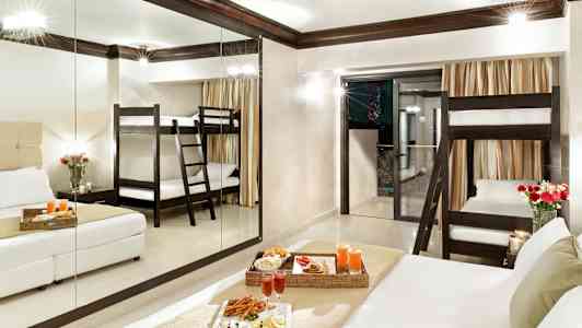 Hotelværelse med en køjeseng, dobbeltseng og serveret måltid. (AI-genereret tekst)