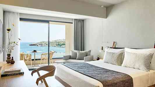 Hotelværelse med moderne indretning og udsigt over havet. (AI-genereret tekst)