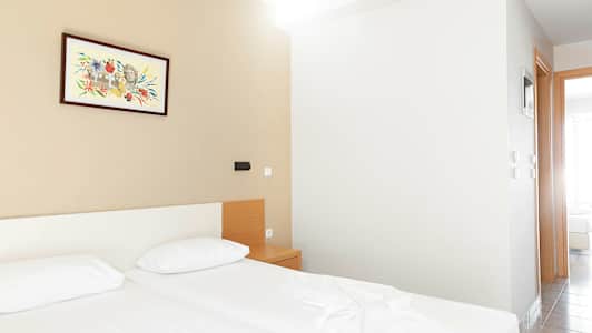 Et hotelværelse med to senge, et natbord og et maleri på væggen. (AI-genereret tekst)