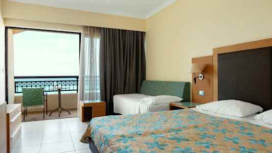 Hotelværelse med senge og altan. (AI-genereret tekst)