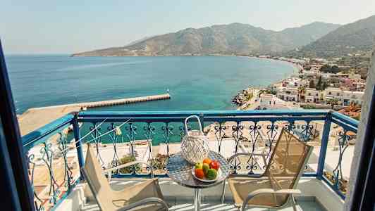 Altan med udsigt over en bugt og en småby ved havet. (AI-genereret tekst)