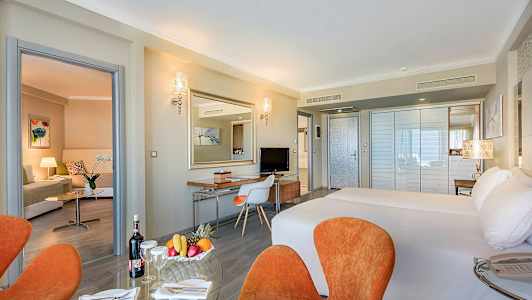 Hotelværelse med dobbeltseng, siddeområde og skrivebord. (AI-genereret tekst)