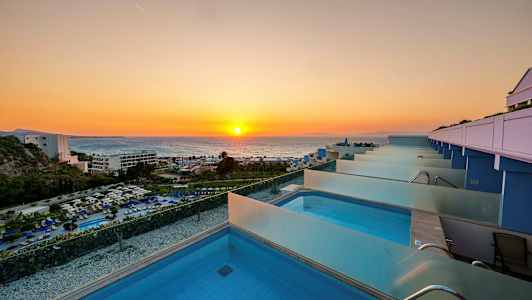 Udsigt over en række private pools med solnedgang over havet i baggrunden. (AI-genereret tekst)