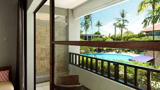 Altan med udsigt over poolområdet, med udemøbler og grønne områder. (AI-genereret tekst)