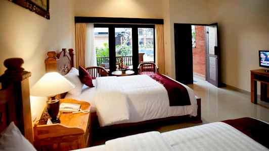 Et hotelværelse med to senge, et stort vindue med udsigt og to stole med et lille bord foran. (AI-genereret tekst)