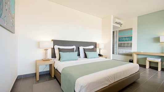 Et hotelværelse med en stor seng, to natborde og moderne indretning. (AI-genereret tekst)