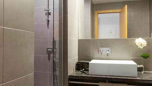 Moderne badeværelse med bruser og håndvask. (AI-genereret tekst)