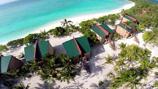 Luftfoto af resort ved stranden med havet i baggrunden. (AI-genereret tekst)