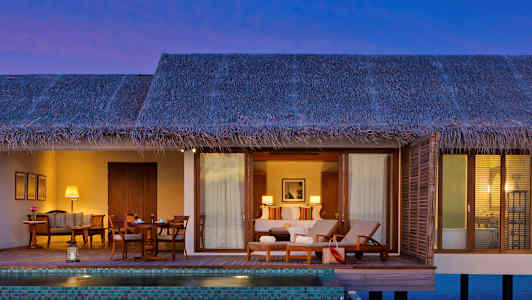 En vandbungalow med en privat pool og møbleret terrasse. (AI-genereret tekst)