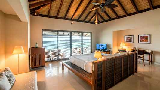 Interiør af et soveværelse med en dobbeltseng og et åbent vindue mod en altan. (AI-genereret tekst)