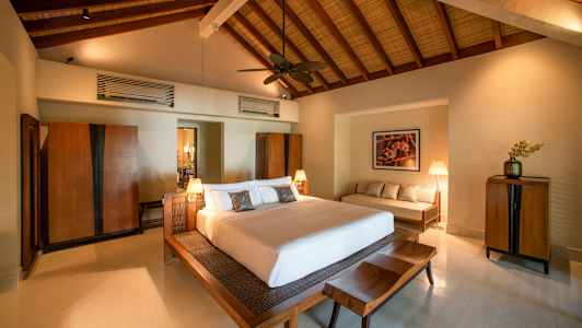 Et soveværelse med en stor seng, træmøbler og højt loft. (AI-genereret tekst)