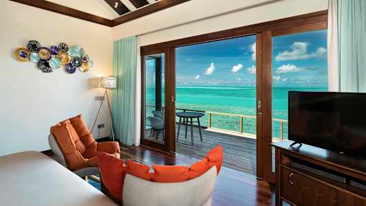 Interiør af hotelværelse med møbler, dekorative elementer og udsigt over havet. (AI-genereret tekst)