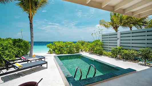 Udsigt fra en veranda med lille pool ved stranden. (AI-genereret tekst)