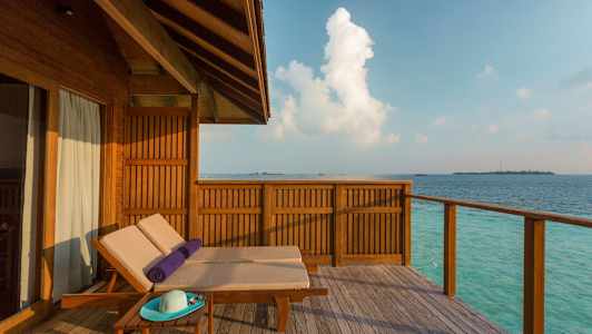 Træterrasse med solvogne ved havet. (AI-genereret tekst)