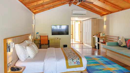 Et lyst indrettet hotelværelse med en dobbeltseng, en fladskærms-TV og siddepladser. (AI-genereret tekst)