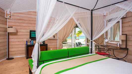 Lyst soveværelse med himmelseng og udsigt til stranden. (AI-genereret tekst)