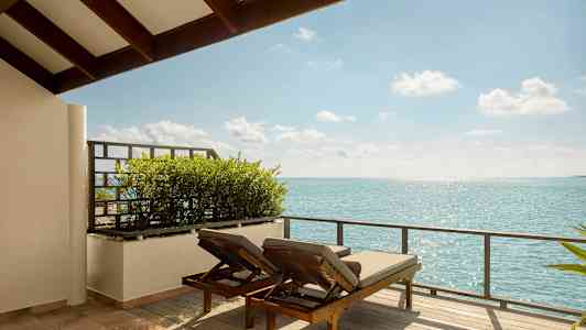 To solsenge på en terrasse med udsigt over havet. (AI-genereret tekst)