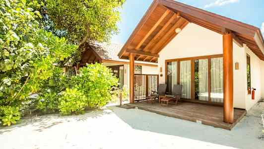 En strandvilla omgivet af frodig vegetation. (AI-genereret tekst)