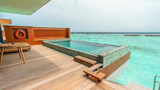 Billede af en terrasse med en privat pool, havet er synligt i baggrunden. (AI-genereret tekst)