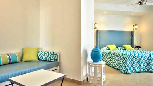 Et hotelværelse med seng, lys indretning og dekorative puder. (AI-genereret tekst)