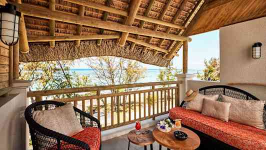 Terrasse med siddepladser, bord og udsigt over havet. (AI-genereret tekst)