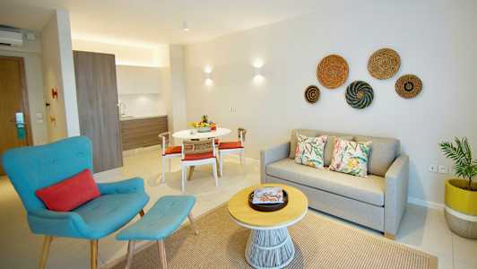 Moderne lejlighed med sofa, lænestol, spisebord og tekøkken. (AI-genereret tekst)