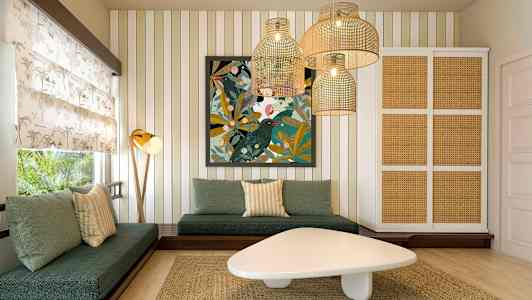 En stue med grønne sofaer, et kunstværk på væggen og hængende lamper i rottingstil. (AI-genereret tekst)